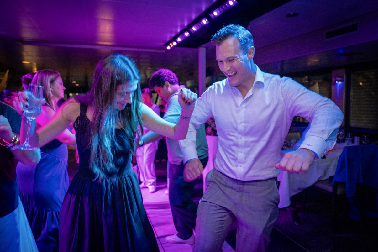 A couple dancing together under purple lights at a Yacht Party
