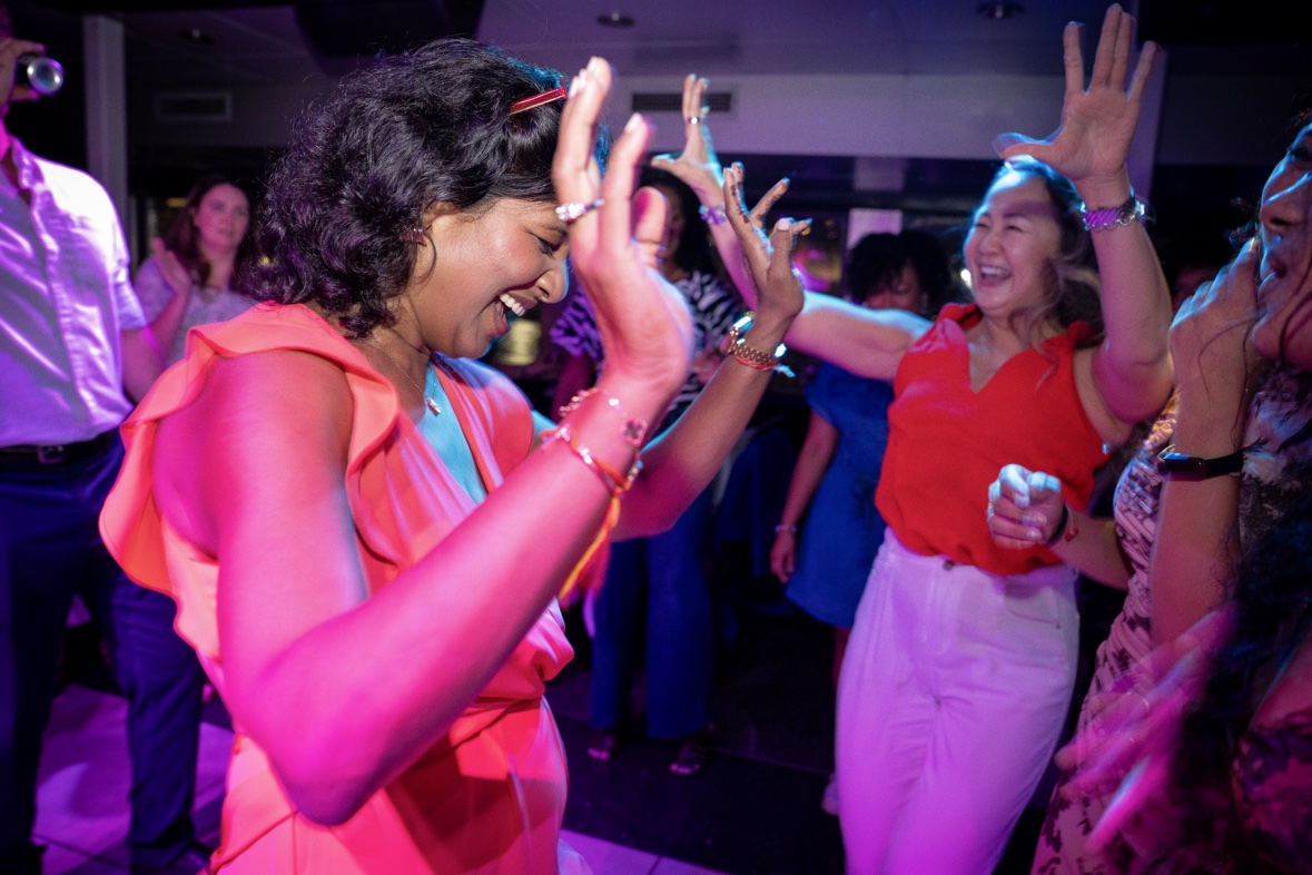 Guests dancing and laughing on a packed party dance floor