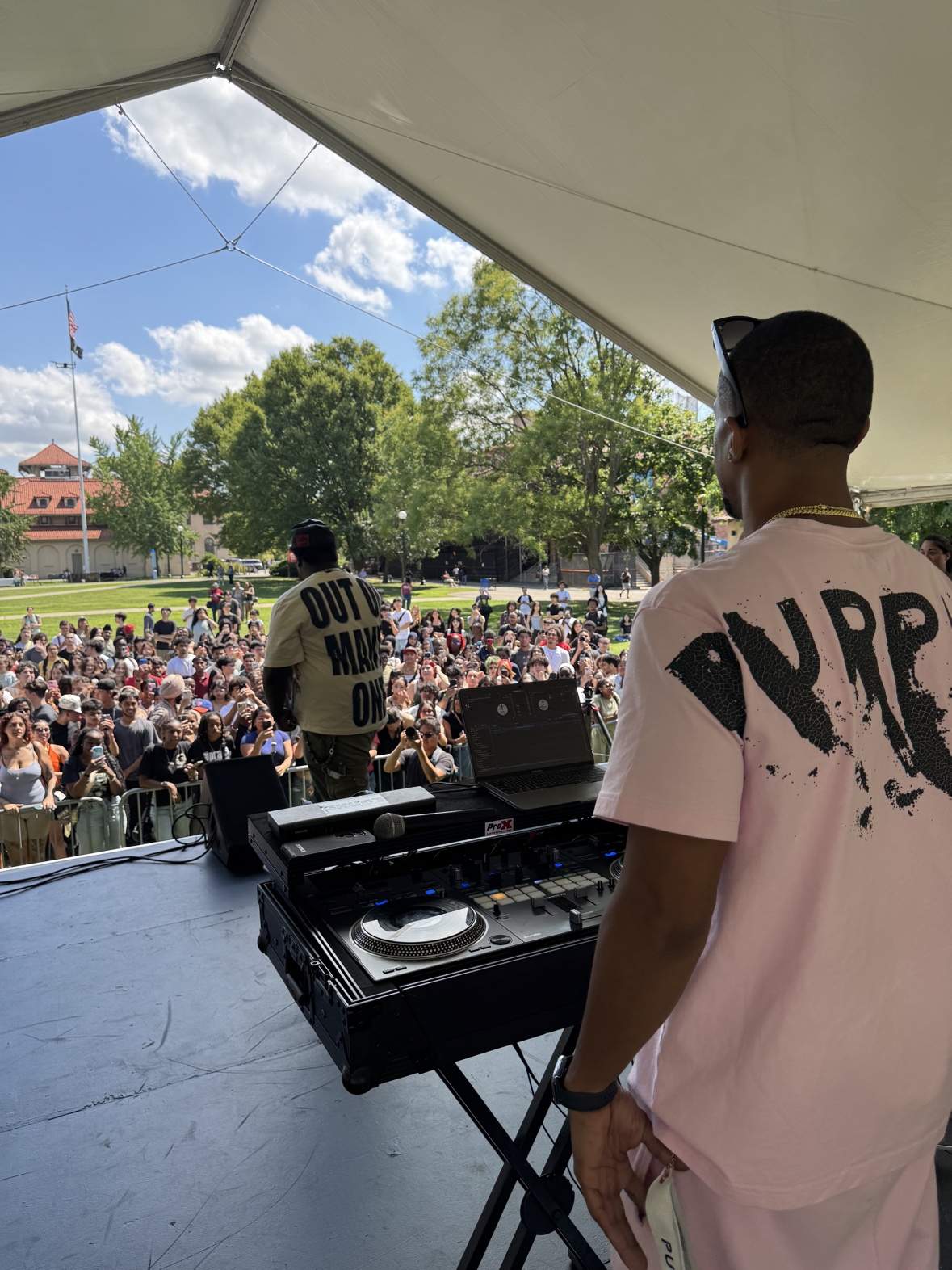 DJ Takeova at the decks before a large outdoor crowd