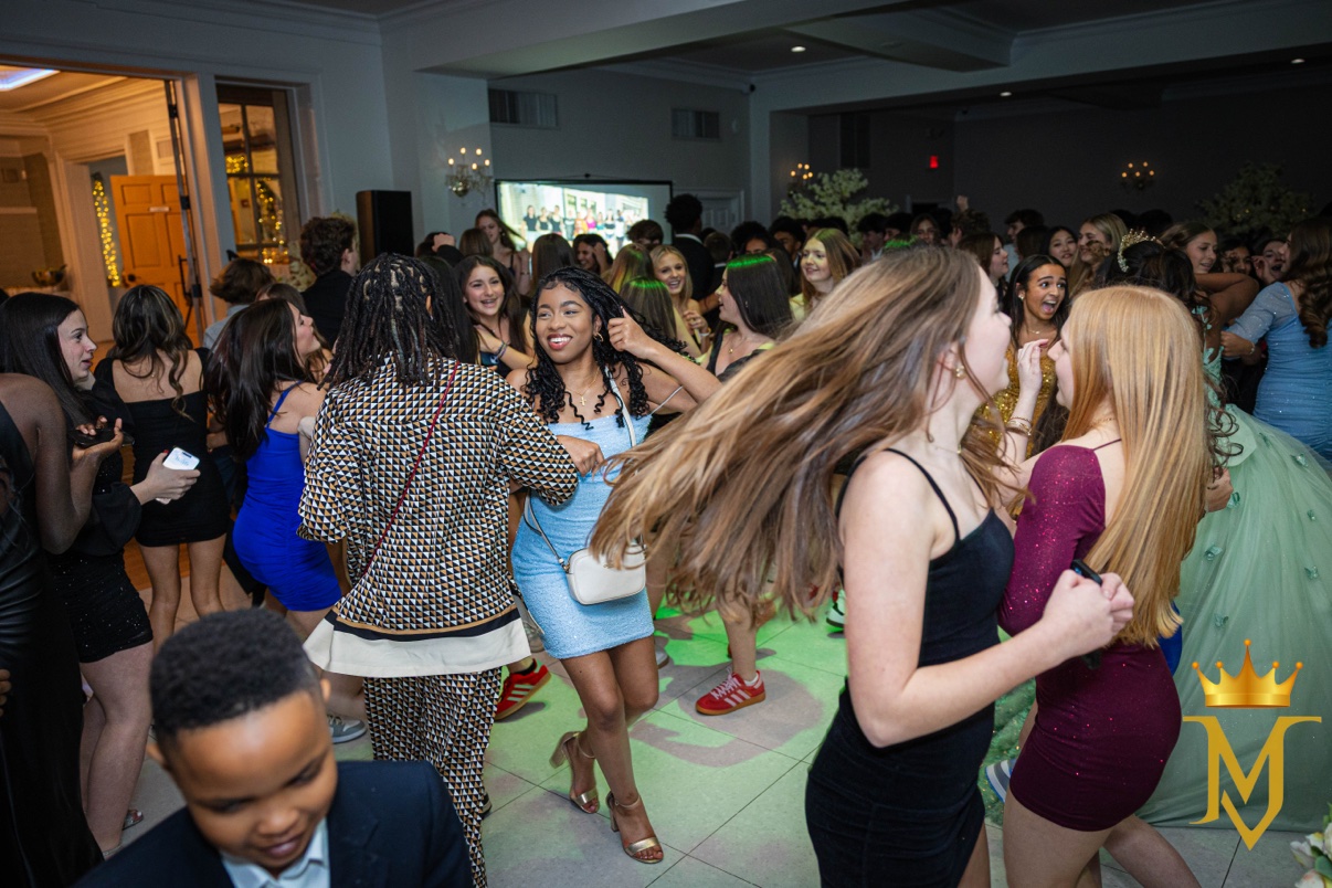 Quincea&ntilde;era in a mint-green gown and tiara dancing with her guests